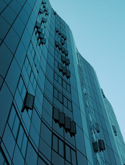 A skyscraper with glass walls and lots of windows.
